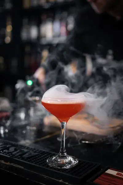 Rød cocktail med røg over glasset
