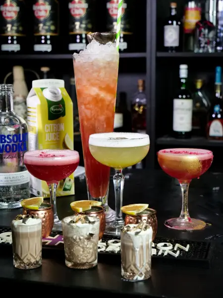 Udvalg af farverige cocktails klar på baren