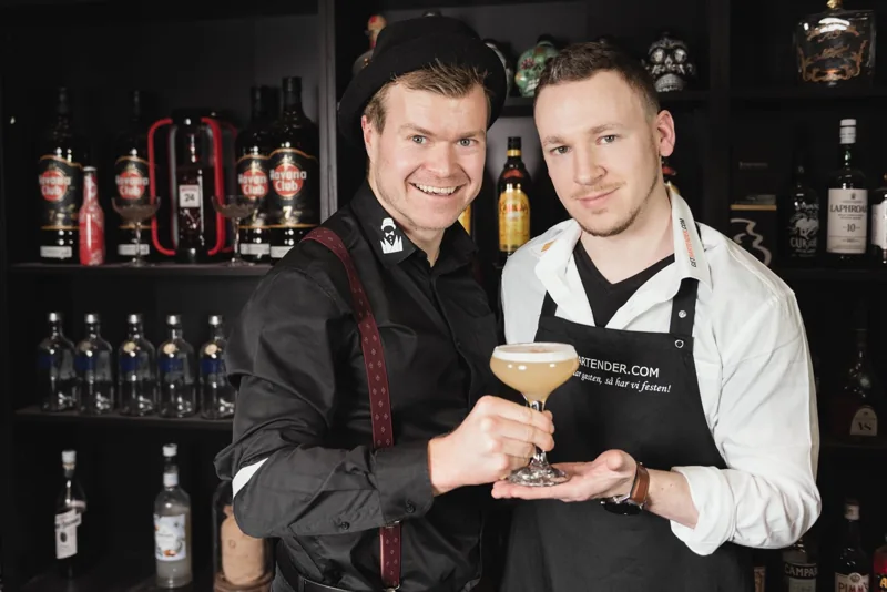 To af GetBartenders bartendere med en friskblandet cocktail